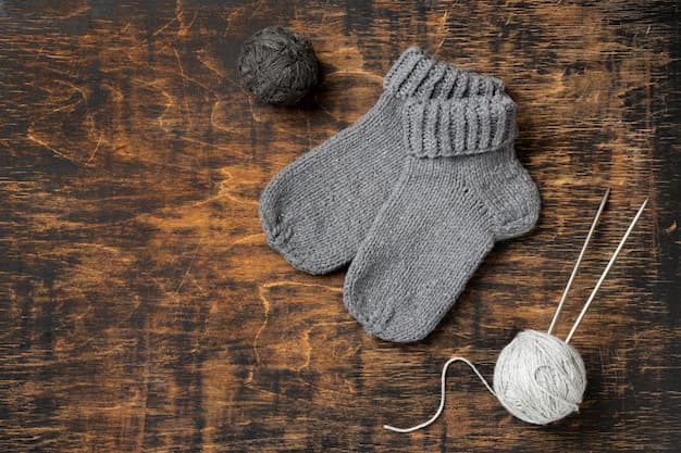 Socks on a wooden table with threads and knitting needles