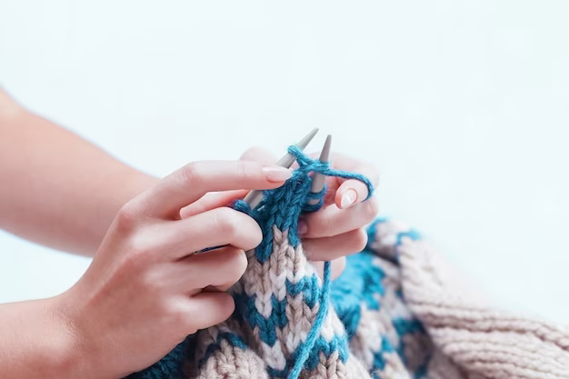 Hands holding knitting needles and knitting, close-up