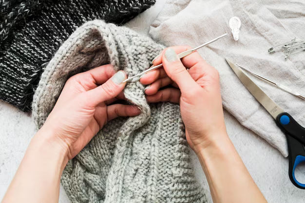 Woman knitting using a crochet hook, top view